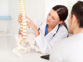 Chiropractor Describing Spine with Patient